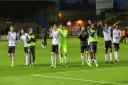 Wanderers players celebrate their win against Carlisle with the travelling supporters
