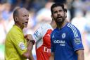 Diego Costa looks away after picking up a yellow card from Mike Dean