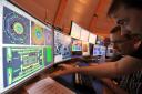 AT THE CONTROLS:  Scientists study computer screens at the European Centre for Nuclear Research (CERN) site near Geneva
