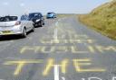 Some of the graffiti in the road. We have deliberately blurred the offensive message.