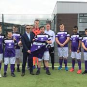 Phil Bird of The PC Support Group presents the Rumworth School football team with their new kit
