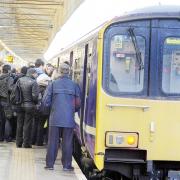 Commuters trying to get on a packed train at Bolton station