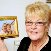 Valerie Nolan holding a holiday photograph of her with late husband Duggie