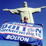 Whites supporter Joel Hughes proudly displaying the Bolton Wanderers flag in front of the iconic Christ the Redeemer statue in Rio de Janeiro