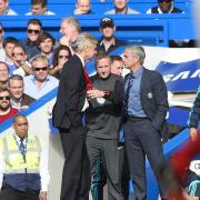 Fourth official Jon Moss gets in between rival bosses Arsene Wenger and Jose Mourinho last weekend