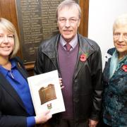Head teacher Helen Phillips presents John Medling and Janet Evans with copies of the book