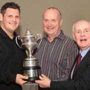 Martin Axford, middle, presents the Anthony Axford Bolton Cricket League title trophy to Christian Walsh, left, joint captain of last season's champions Farnworth Social Circle with league chairman Mike Hall, right