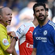 Diego Costa looks away after picking up a yellow card from Mike Dean