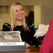 MILESTONE: Lisa Schofield, editor's secretary at The Bolton News, gives out a piece of the 150th anniversary cake
