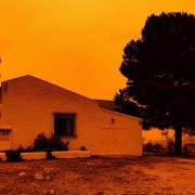 An orange sky is seen over a building in Navares, south-eastern Spain (Javier Carrion/Europa Press via AP)