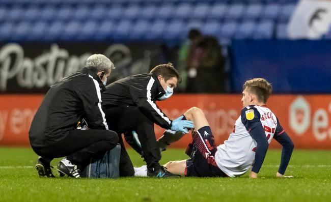 Harry Brockbank is treated for a hamstring injury on the pitch in Wanderers' 1-1 draw against Mansfield
