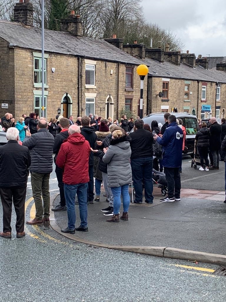 People line Halliwell Road near the pub on Monday