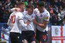 Dion Charles, Conor Bradley and Eoin Toal celebrate a goal for Wanderers against Exeter City
