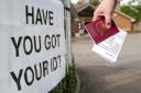 File photo dated 03/05/18 of a voter carrying his passport along with his poll card, as he makes his way to vote at The Vyne polling station in Knaphill, as ministers have reminded voters in England to check they have an accepted form of photographic