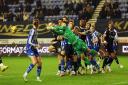Wigan Athletic's Sam Tickle punches corner under pressure from Bolton Wanderers' Aaron Collins