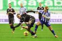Bolton Wanderers' Paris Maghoma holds off the challenge from Wigan Athletic's Matt Smith