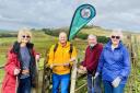 Rotarians Pat Rothwell, Christopher Hill, Graham and Susan Stamford installing new waymarker roundels on a stretch of the Rotary Way Bolton with Rivington Pike in the background