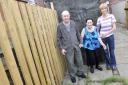 VICTIMS?: Harry and Irene Clarke, with daughter Fay beside the fence which incorporates the allegedly stolen timber
