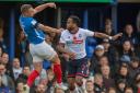 Nathan Delfouneso challenges Portsmouth's Lee Brown