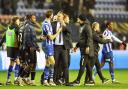 Bolton Wanderers manager Ian Evatt argues with Wigan Athletic's Charlie Goode at the end of the match