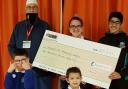 AID: Supporters of Azhar Academy hand over a £10,000 cheque for the minibus appeal at Thomasson Memorial School