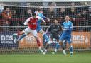 Conor Bradley goes up for a header with Danny Andrew in Wanderers' 2-1 win at Fleetwood