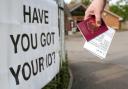 File photo dated 03/05/18 of a voter carrying his passport along with his poll card, as he makes his way to vote at The Vyne polling station in Knaphill, as ministers have reminded voters in England to check they have an accepted form of photographic