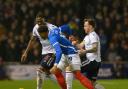 Gethin Jones and Ricardo Santos tussle with Portsmouth's Kusini Yengi in Monday night's defeat at Fratton Park