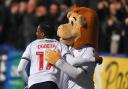 Nat Ogbeta hugs Lofty the Lion after opening the scoring against Oxford United