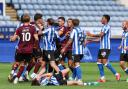 Harry Gray lies on the floor as players from both sides scuffle following the red card incident