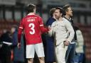 Wrexham co-owners Rob McElhenney and Ryan Renyolds with Lewis Brunt on the pitch