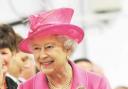 The Queen was dressed in a fuchsia outfit with matching hat, a black bag, gloves and shoes