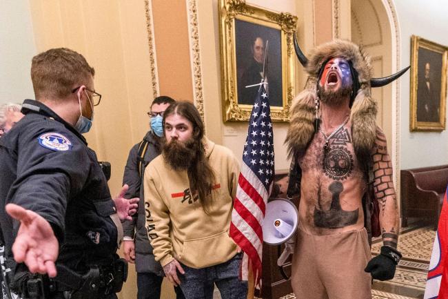 Supporters of then President Donald Trump, including Jacob Chansley, right with fur hat, are confronted by U.S. Capitol Police officers outside the Senate (Manuel Balce Ceneta/AP)