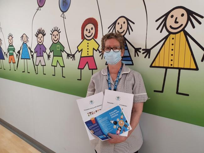 Steffie El Hassan holding her patient education leaflets for children with diabetes.