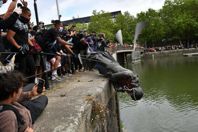 Protesters throw statue of Edward Colston into Bristol harbour during a Black Lives Matter protest rally