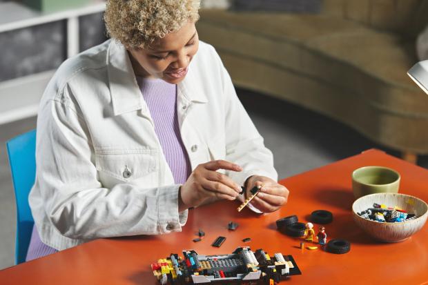 The Bolton News: A woman putting together the LEGO Delorean. Credit: LEGO
