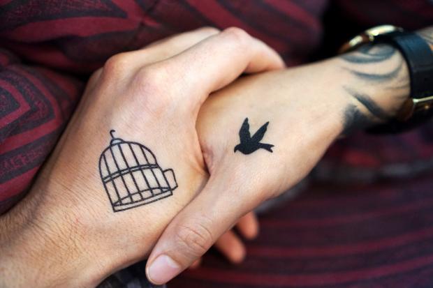 The Bolton News: Two people with tattoos holding hands (Canva)