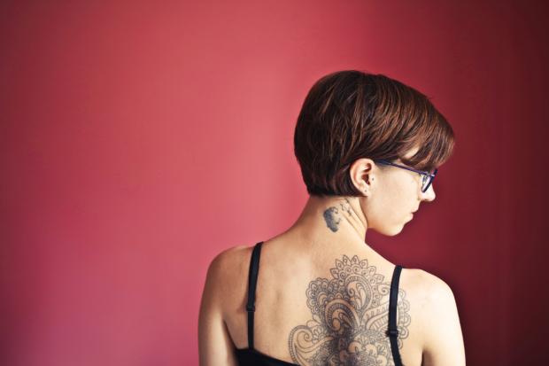 The Bolton News: A woman with back tattoos (Canva)