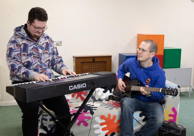 The Bolton News: A resident and a worker at Backup North West using music sessions to manage well being - funded by the National Lottery