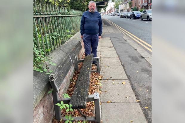 Cllr David Wilkinson stood next to a broken bench in Westhoughton