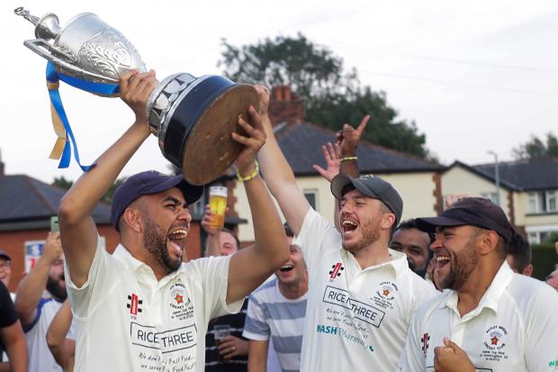 WINNERS: Astley Bridge skipper, Yasir Rashid, celebrates lifting the Hamer Cup with David Cryer, right. . Picture by Harry McGuire