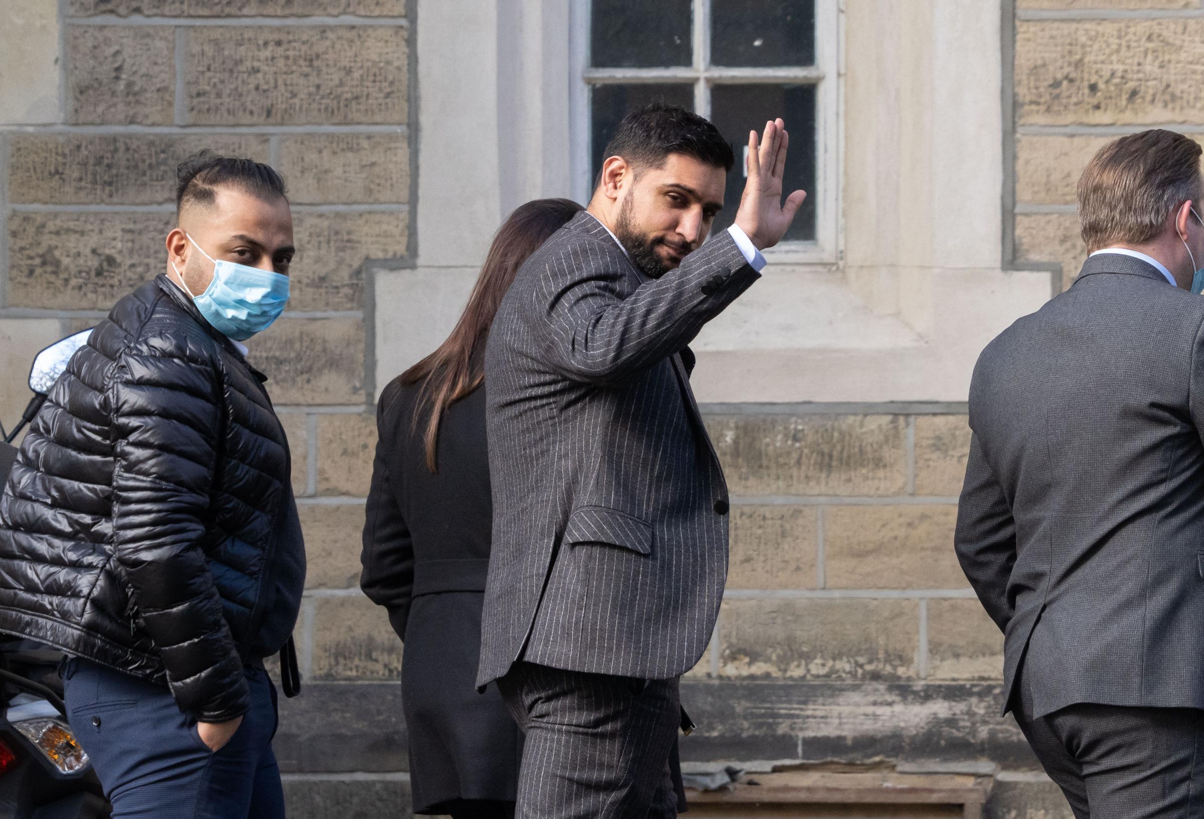 Former world boxing champion Amir Khan, waves as he arrives at Snaresbrook Crown Court, in east London, where three men are accused of robbing the boxer of a diamond watch at gunpoint. Khans 72,000 custom-made Franck Muller watch was stolen in High
