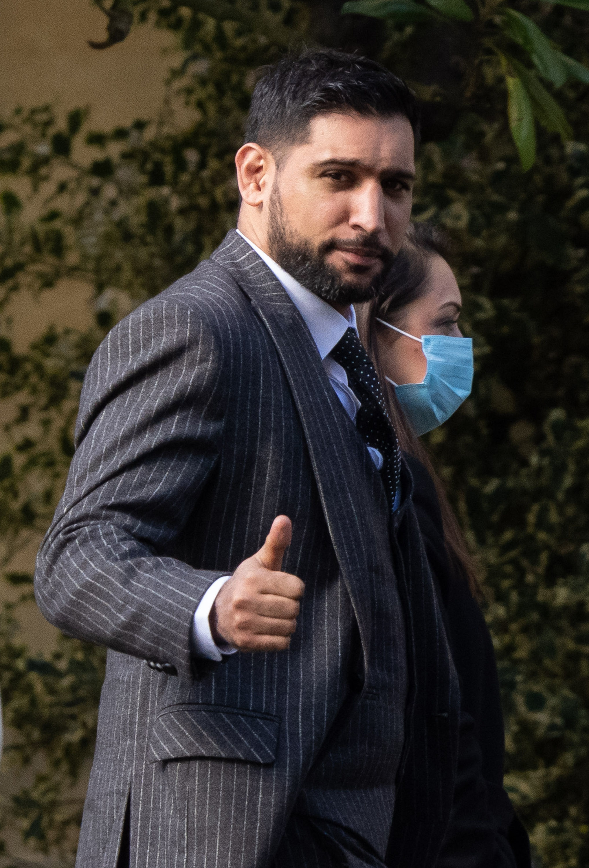 Former world boxing champion Amir Khan, gives a thumbs up as he arrives at Snaresbrook Crown Court, in east London, where three men are accused of robbing the boxer of a diamond watch at gunpoint. Khans 72,000 custom-made Franck Muller watch was stolen