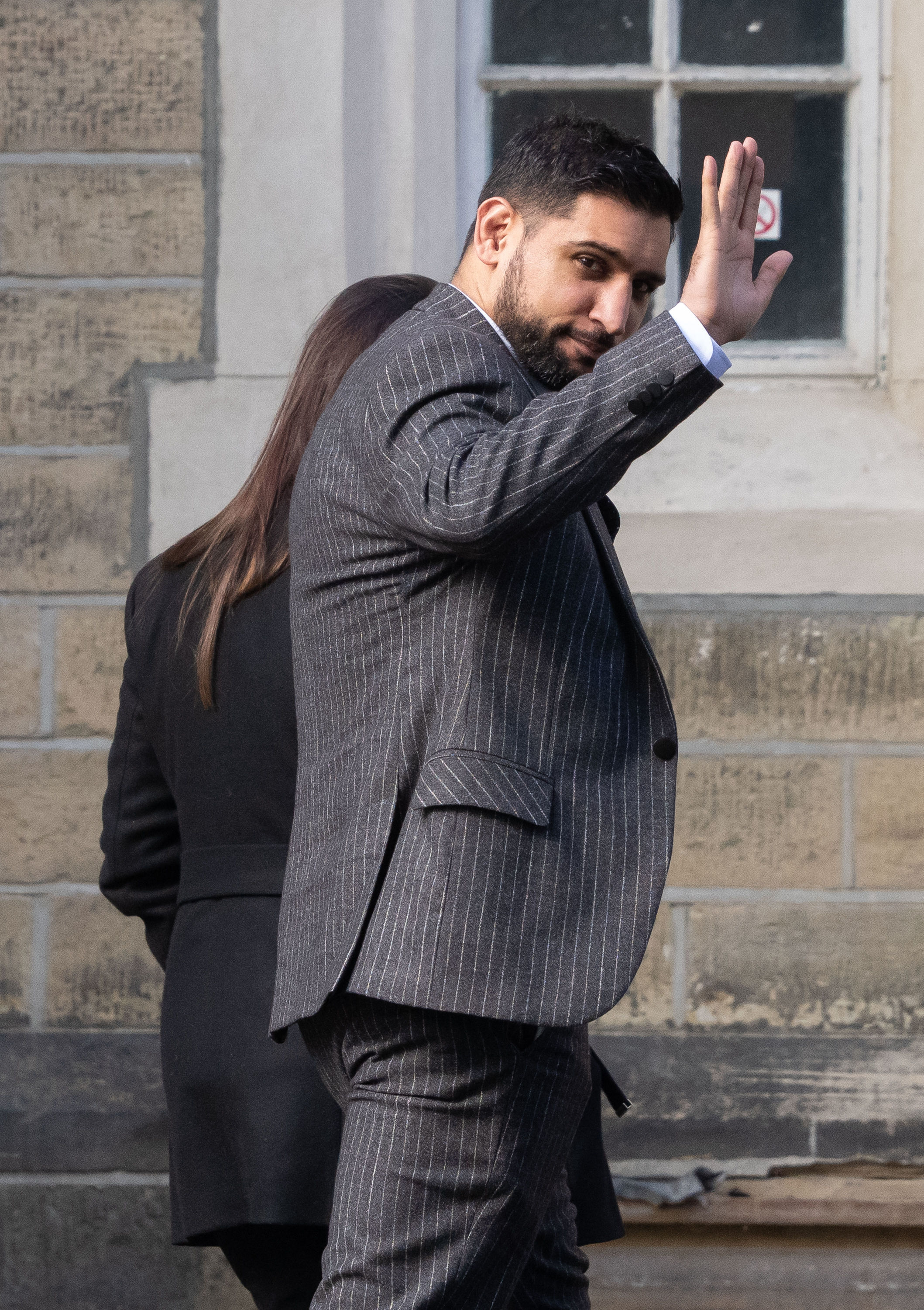 Former world boxing champion Amir Khan, waves as he arrives at Snaresbrook Crown Court, in east London, where three men are accused of robbing the boxer of a diamond watch at gunpoint. Khans 72,000 custom-made Franck Muller watch was stolen in High