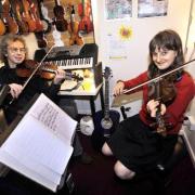 IN TUNE: Violin teacher, Matt Haigh and pupil Sofia Wood, aged 11, from Smithills school, Bolton, practise for the 2009 Christmas concert to raise money for the Marie Curie nurses appeal