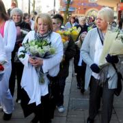 PROTEST: Campaigners march to Victoria Square, Bolton, to lay flowers in a protest against plans to remove roadside tributes.