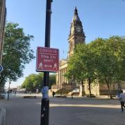 A coronavirus social distancing sign in front of Bolton Town Hall in Victoria Square