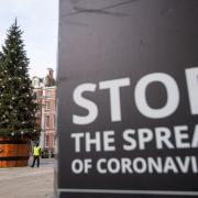 A Christmas tree is seen alongside coronavirus signage in Covent Garden, London.