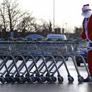 A man dressed as Father Christmas collects trolleys at a Morrisons supermarket in Belle Vale, Liverpool..