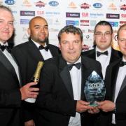 THE INNOVATORS: Andrew Roberts, managing director of Pennine Telecom, centre, pictured with staff, and far right, Andy Smith of the University of Bolton which sponsored the award jointly with the Hakim Group